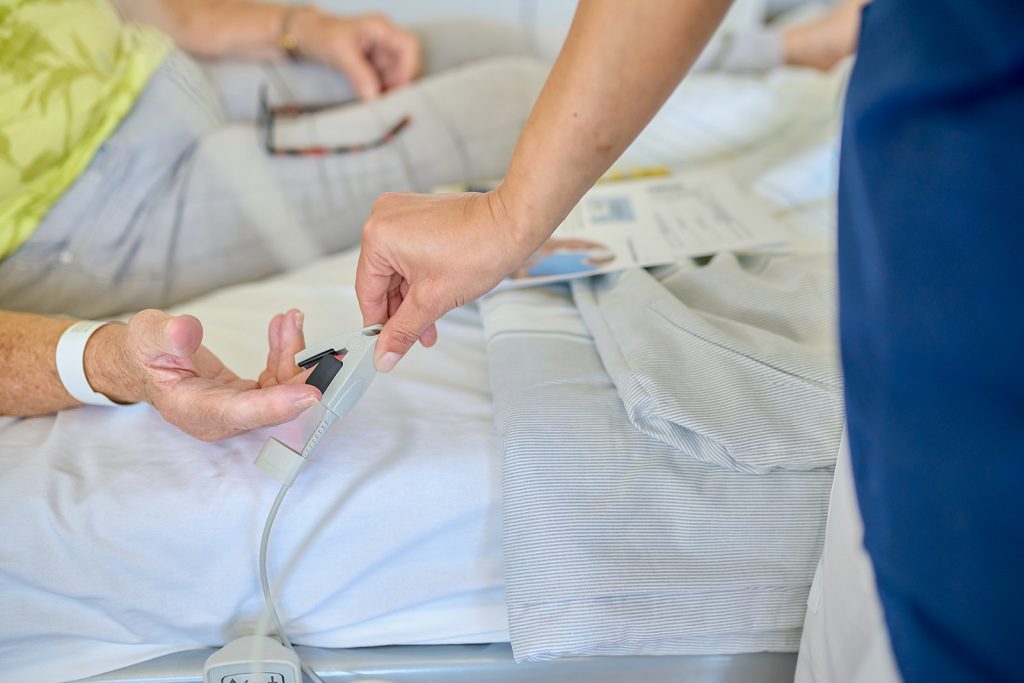 Pflegekraft misst Sauerstoff an Patienten